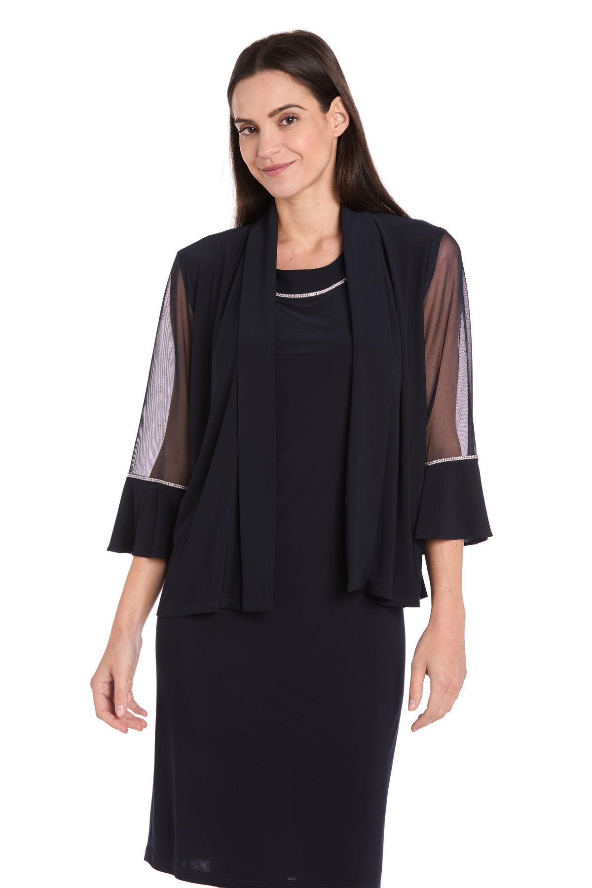 A woman models the R&M Richards 3747P Petite Two-Piece Party Dress with a matching sheer-sleeved black jacket, standing against a plain white background.